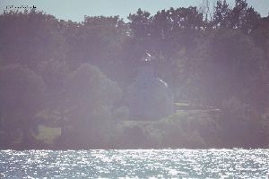 Lighthouse on hill across the water.