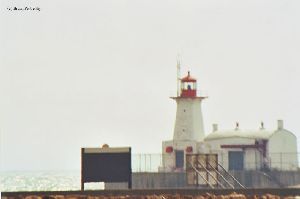 Lighthouse with sparkling lake in the background.
