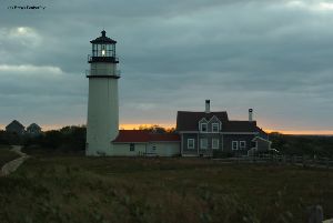 The sun sets behind the lighthouse.