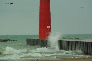 Waves crash against the breakwall.