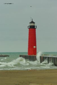 Waves break over the breakwall.