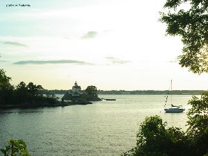 A sailboat and the tower at sunset.