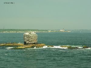The remains of the Whale Rock Lighthouse with the Beavertail Lighthouse in the background.